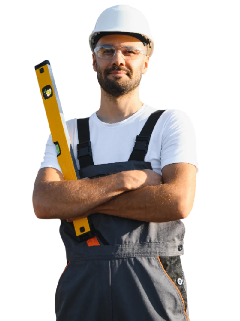 Hombre de obra con casco y gafas de seguridad, sosteniendo un nivel de construcción, vestido con overol gris, mostrando confianza y profesionalismo en un entorno de trabajo.